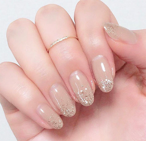 Gold sparkling glitter on nude color gel nail. Done by Weekly gel
