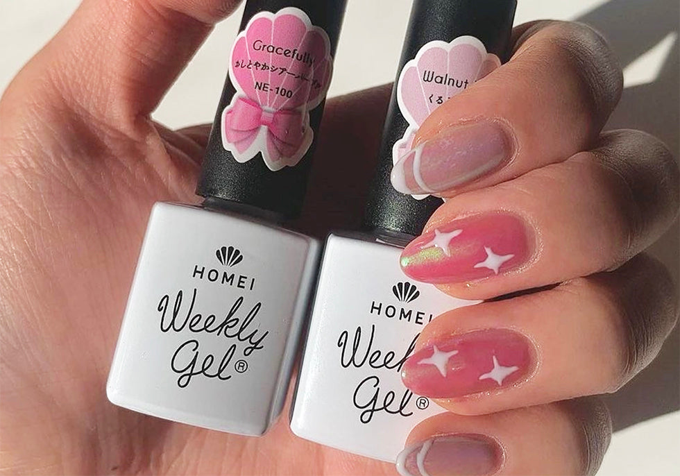 A hand with gel nails, holiding Weekly Gel NE-100 and WG-22